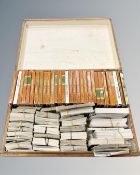 A wooden box containing a large collection of miscellaneous cigarette cards, all loose.