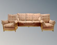 An Ercol elm three piece lounge suite : three seater settee and pair of lounge chairs