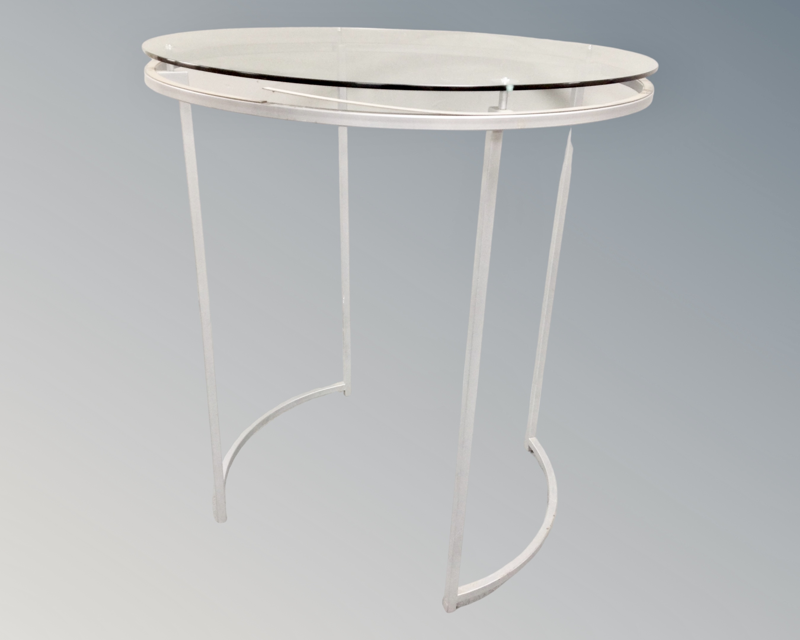A pair of circular metal glass topped shop display stands / clothes racks with hangers