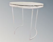 A pair of circular metal glass topped shop display stands / clothes racks with hangers