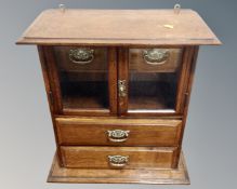 An Edwardian oak smoker's cabinet fitted with two drawers