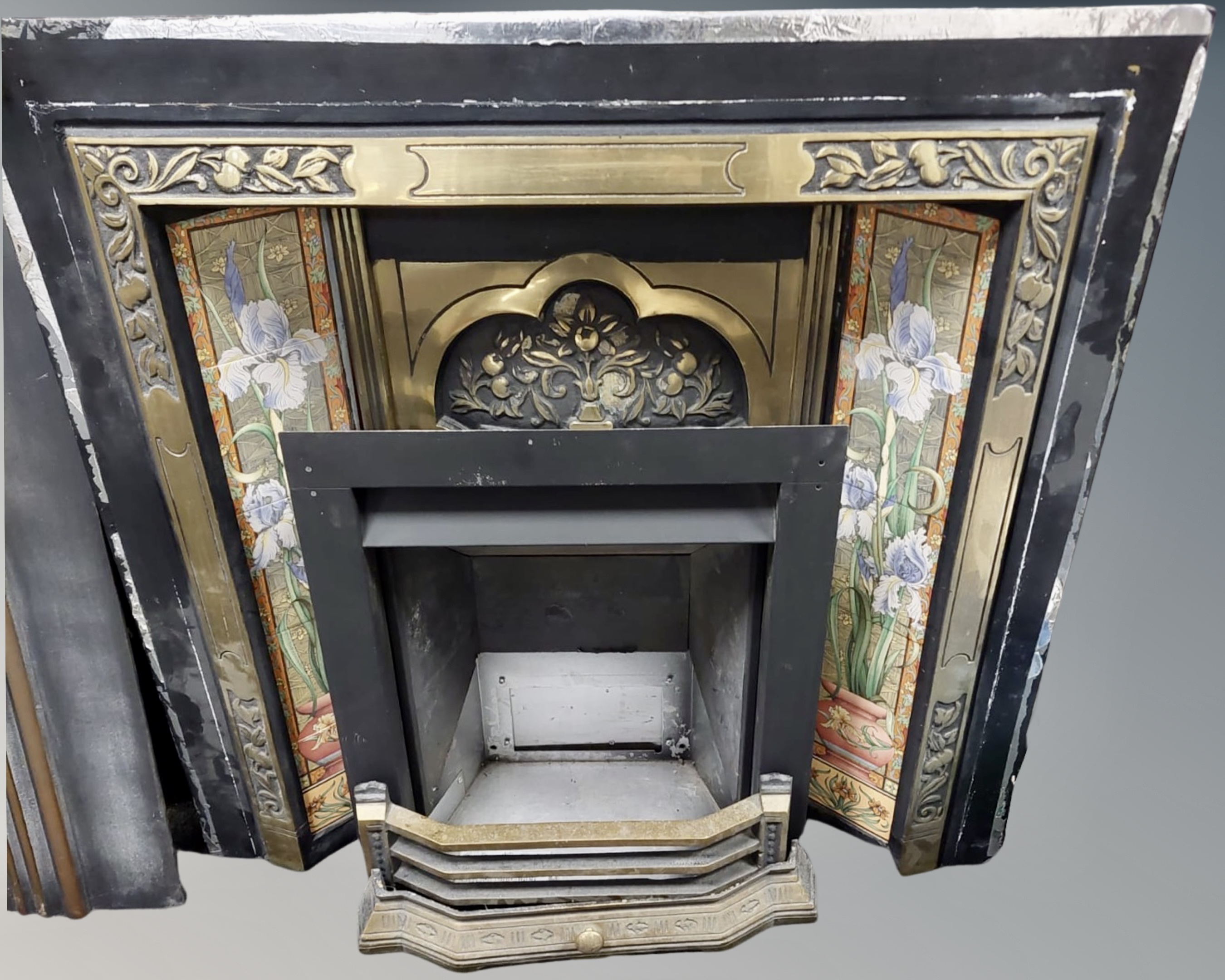 A cast iron and brass tiled fire surround with insert