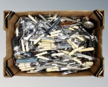 A box containing a large quantity of plated and stainless steel flatware and kitchen utensils.