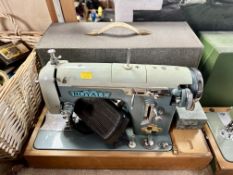 A vintage Royale sewing machine with foot pedal in case.