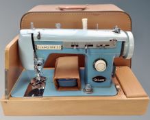 A Seamstress Zigzag deluxe sewing machine in case.