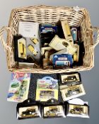 A wicker basket containing assorted boxed die cast vehicles including Ringtons, Matchbox,