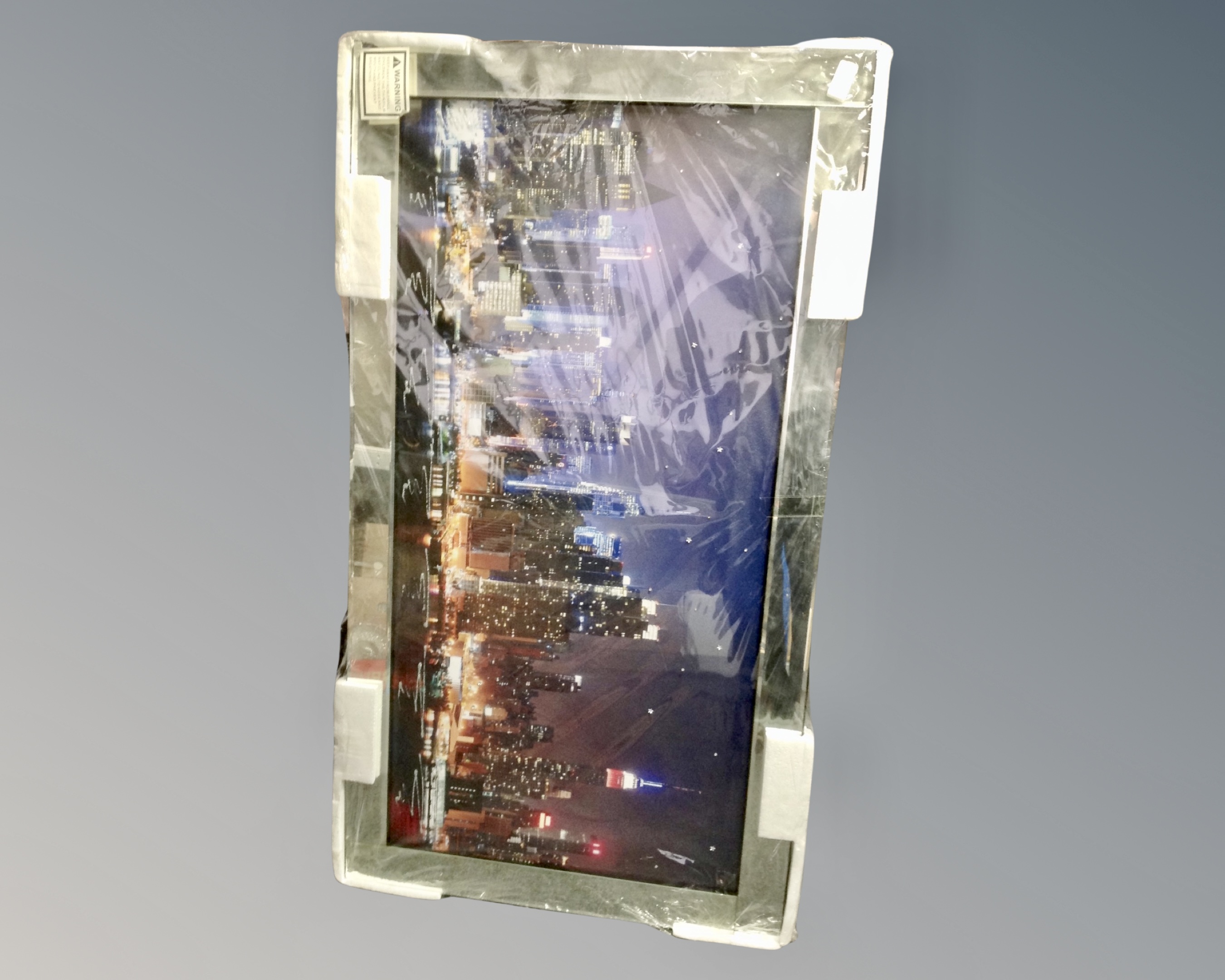A contemporary picture mirror depicting a city skyline, 112cm by 62cm.