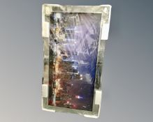 A contemporary picture mirror depicting a city skyline, 112cm by 62cm.