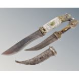 A large hunting knife with etched wolf decoration and wolf head handle together with an Eastern