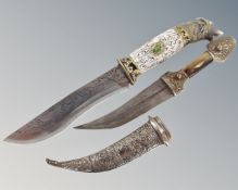 A large hunting knife with etched wolf decoration and wolf head handle together with an Eastern