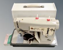 A vintage Singer electric sewing machine with lead and pedal.