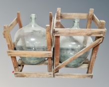 Two glass carboys in wooden stands.