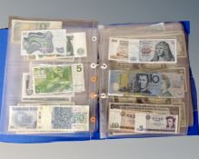 A binder containing assorted world bank notes, humorous American $3 bills etc.