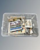 A large plastic crate containing a vast quantity of loose stamps, mainly franked but not all,