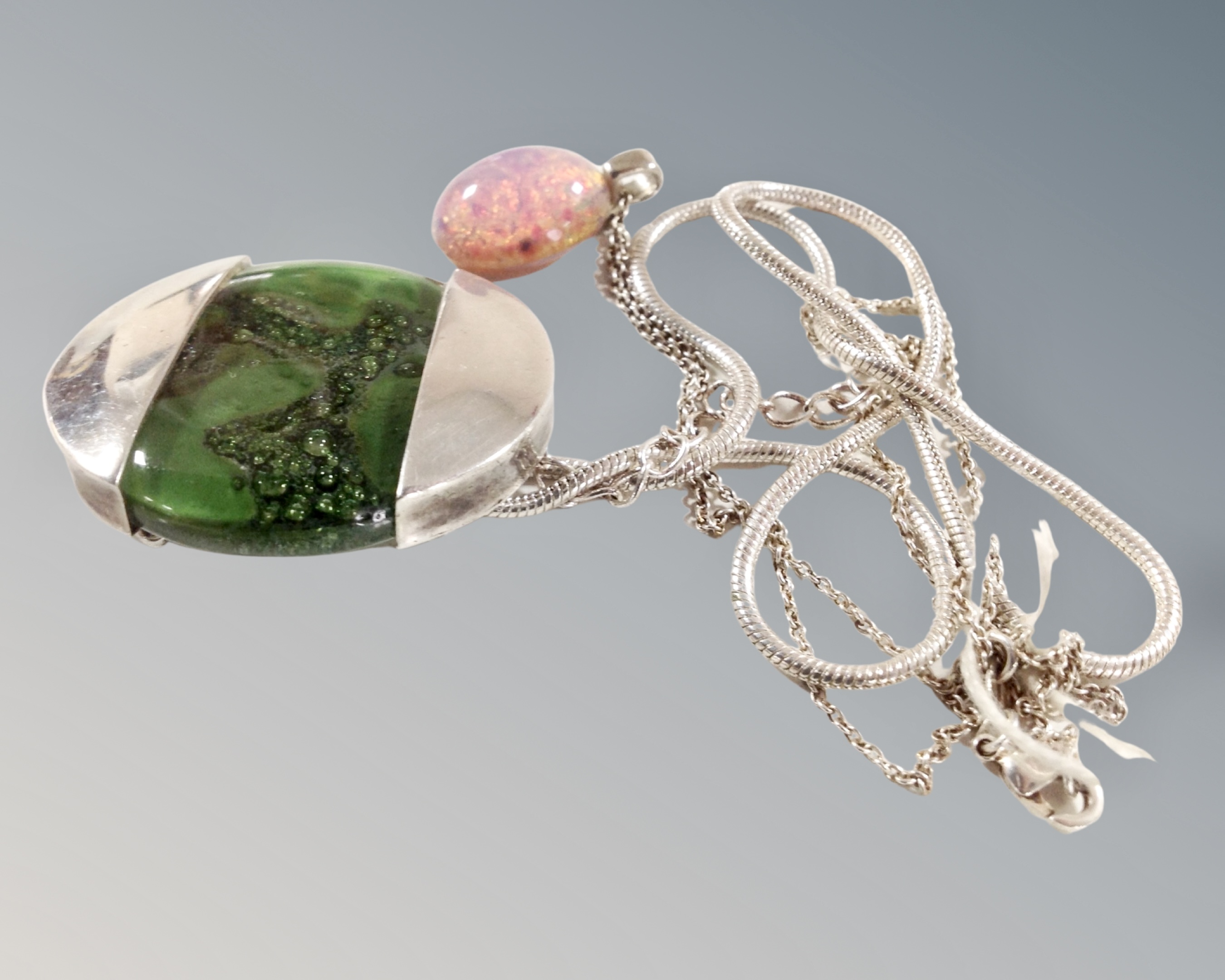 A large green glass and silver pendant on snake chain together with an opal doublet pendant on