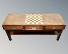 A rectangular low coffee table with chessboard top and brass drop handles.