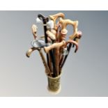 A brass embossed stick stand containing a collection of walking sticks.