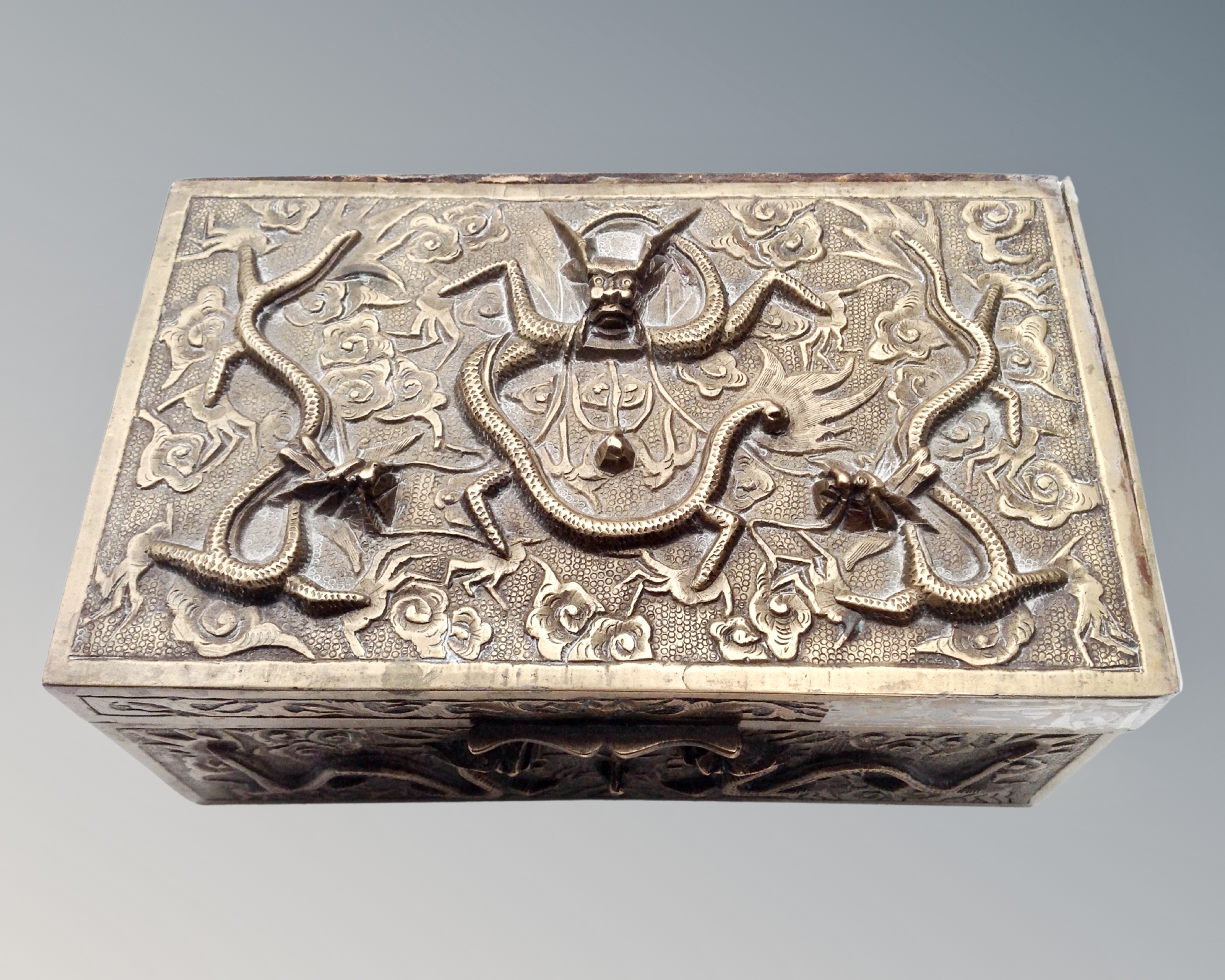 A South-East Asian heavy brass embossed cigarette box.