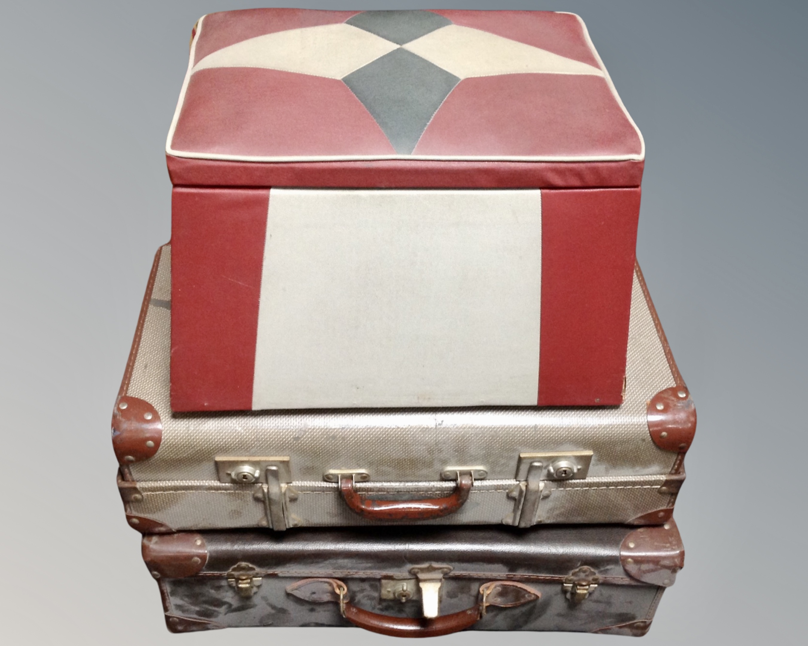 Two vintage luggage cases and a storage footstool.