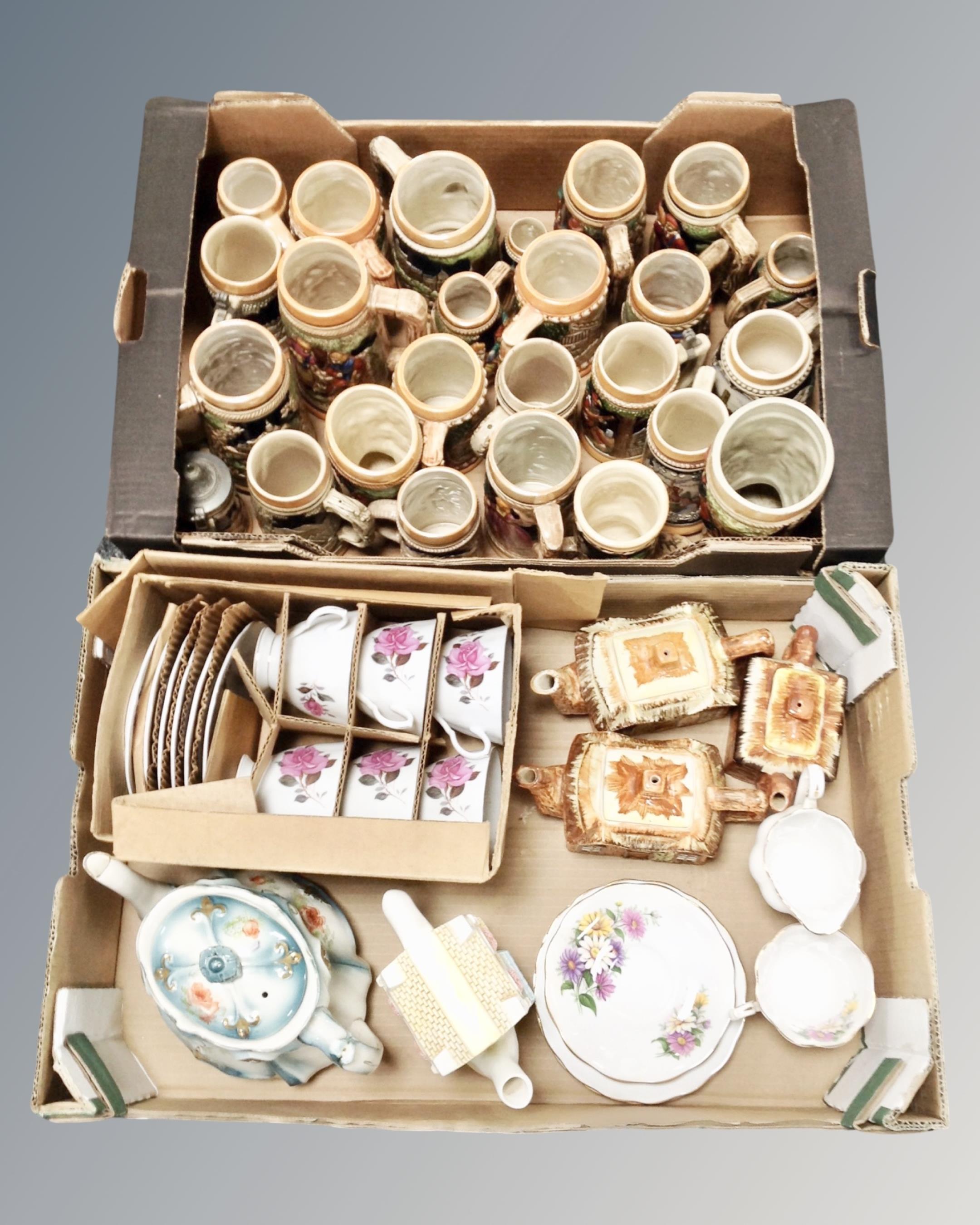 Two boxes containing a large quantity of German pottery steins, cottageware three piece tea set,