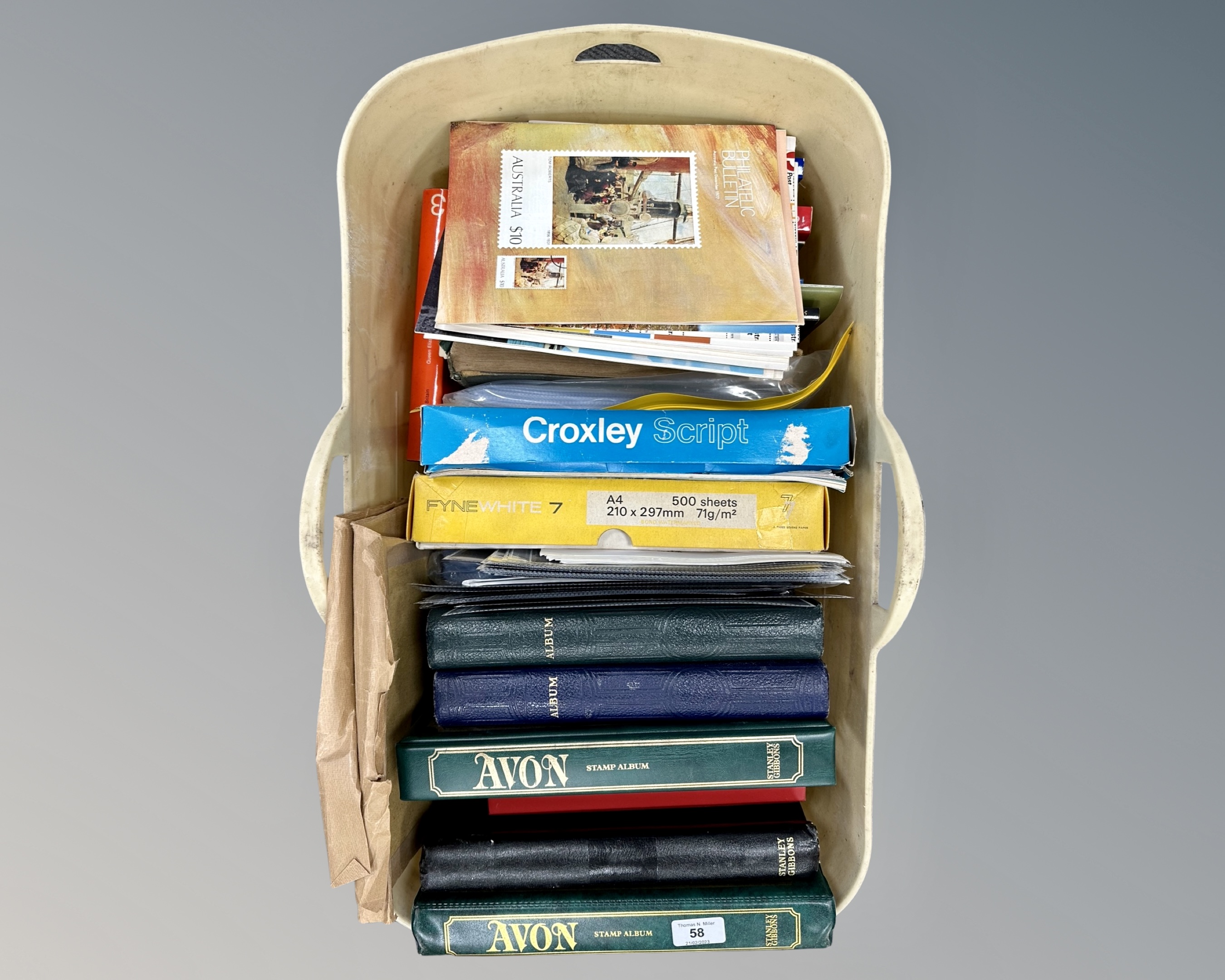 A crate containing numerous stamp albums (all empty), folders, stamp collecting reference books,