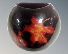 A Poole vase decorated with autumn leaves.