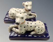 A pair of Staffordshire crackle glazed reclining dalmatians on cushions.