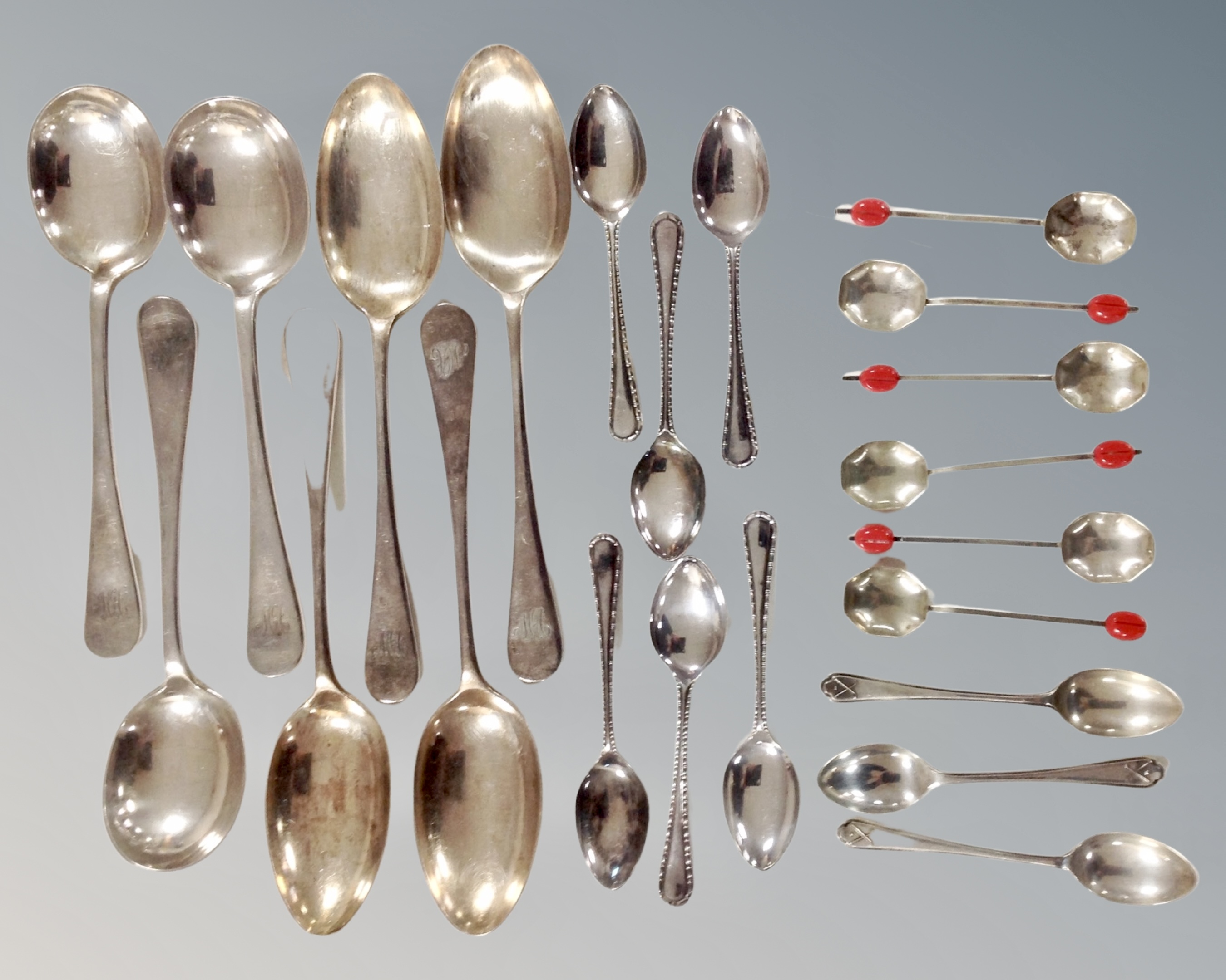 A quantity of assorted plated spoons together with three silver teaspoons.