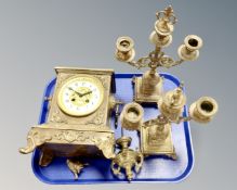 A brass three piece clock garniture set.