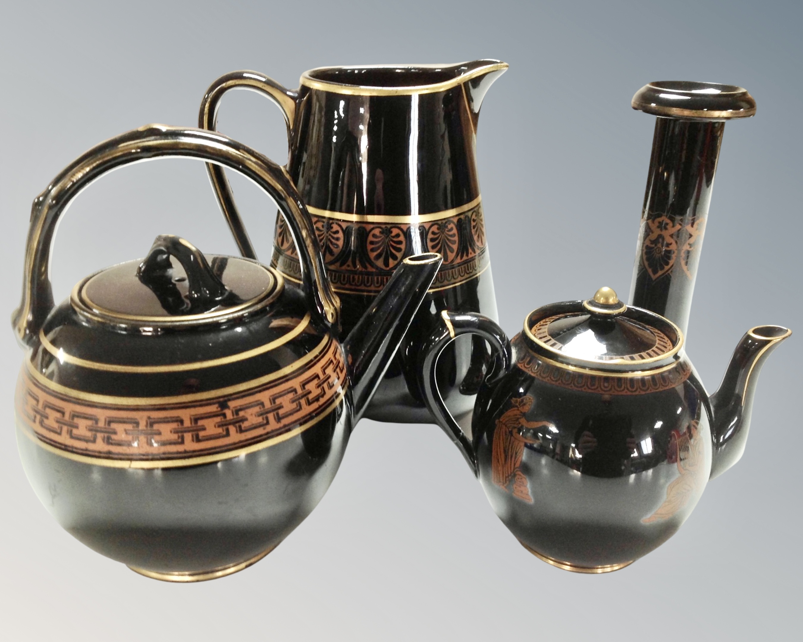 A tray of Greek style ceramics comprising of two teapots, a jug and a candlestick.