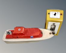 A 20th century coin operated model boat, with operating terminal.