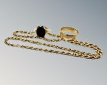 A 9ct gold band ring, another 9ct ring with a black stone and a 9ct gold rope twist chain.