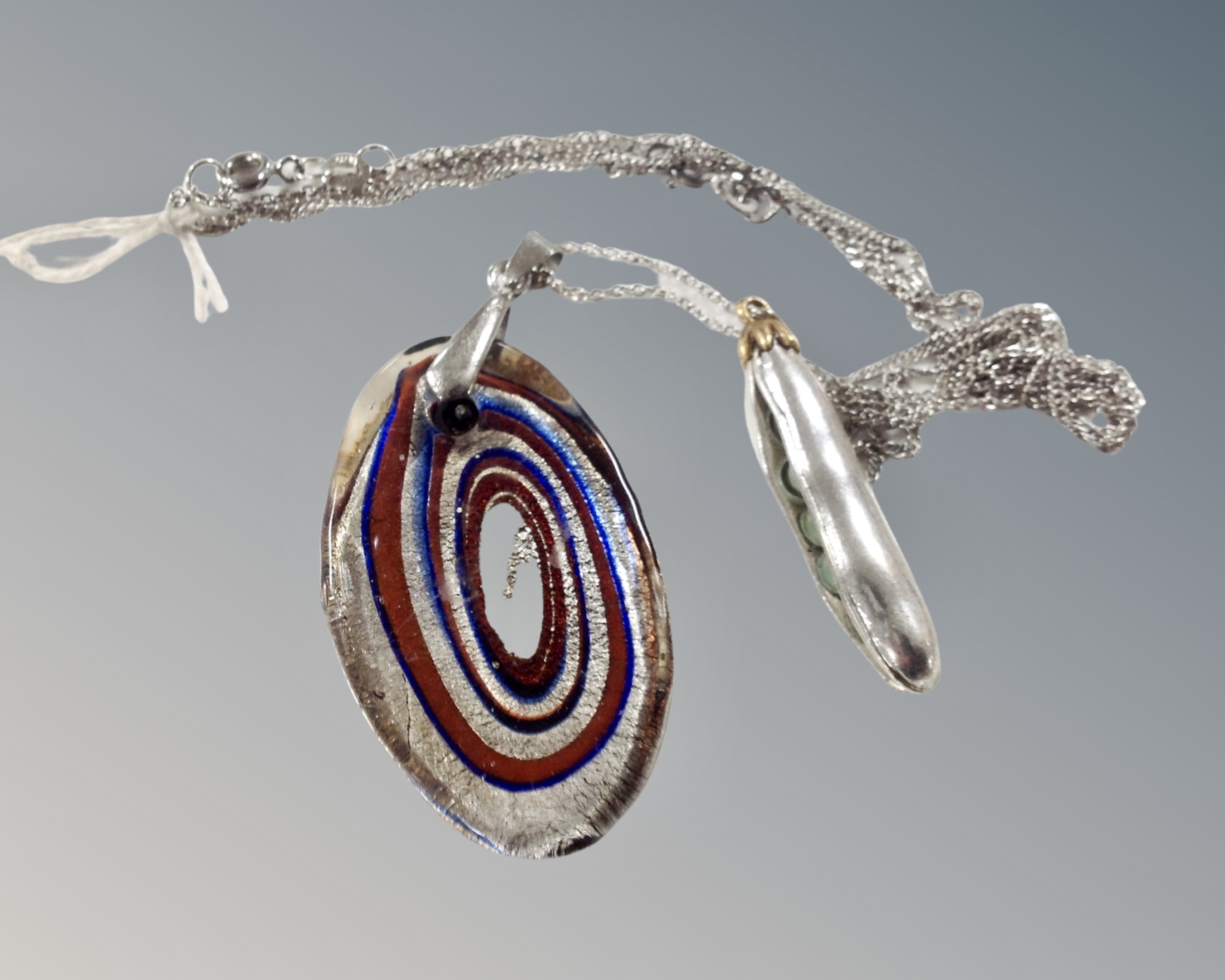A white and yellow metal peapod on fancy silver chain and a Murano glass pendant on 18ct gold