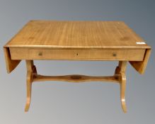 An early 20th century inlaid mahogany flap sided library table fitted a drawer