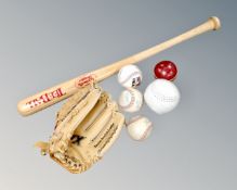 A Louisville Slugger baseball bat together with catchers glove and five baseballs.