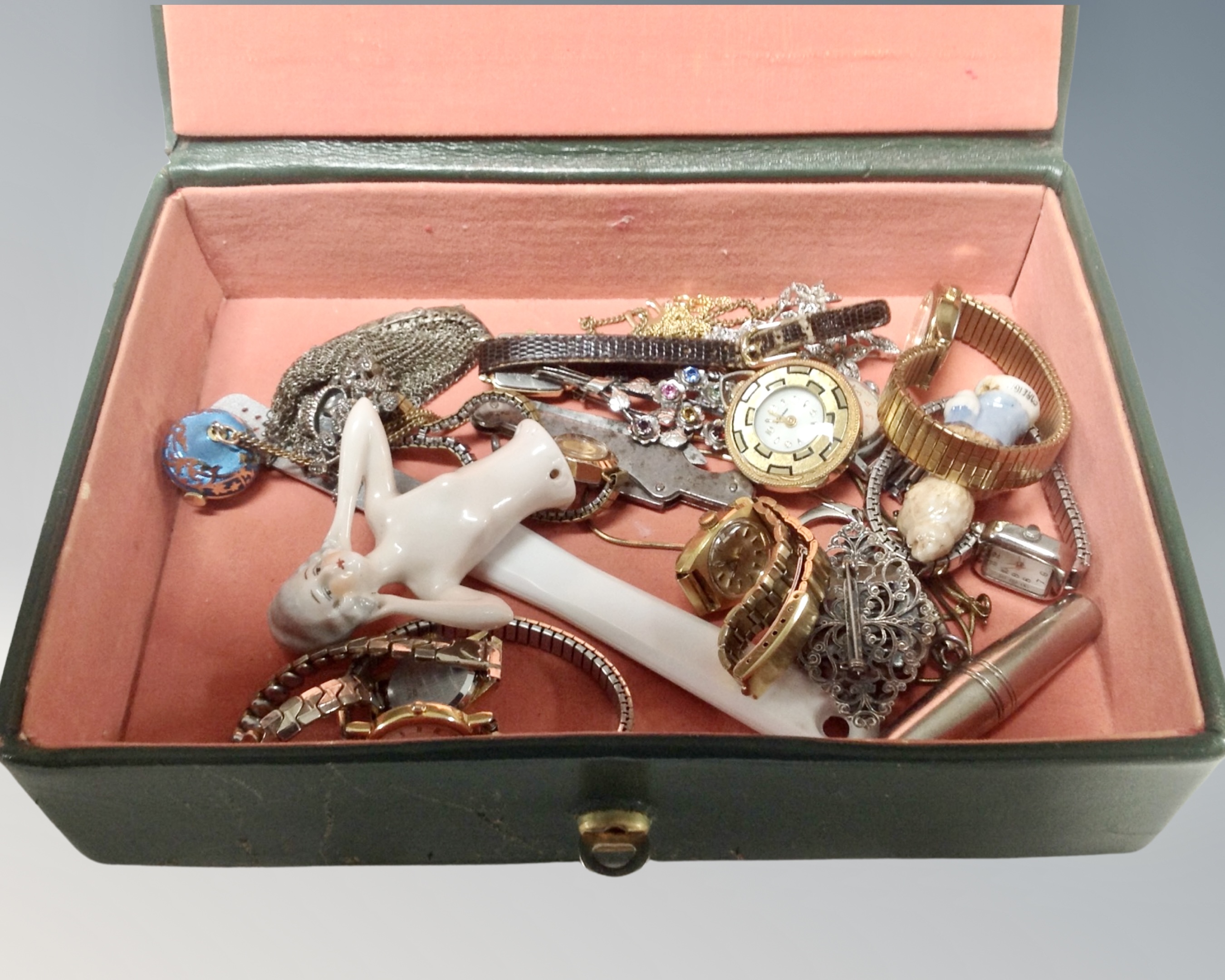 A jewelry box containing assorted costume jewelry, ladies wrist watches, china dolly topper,