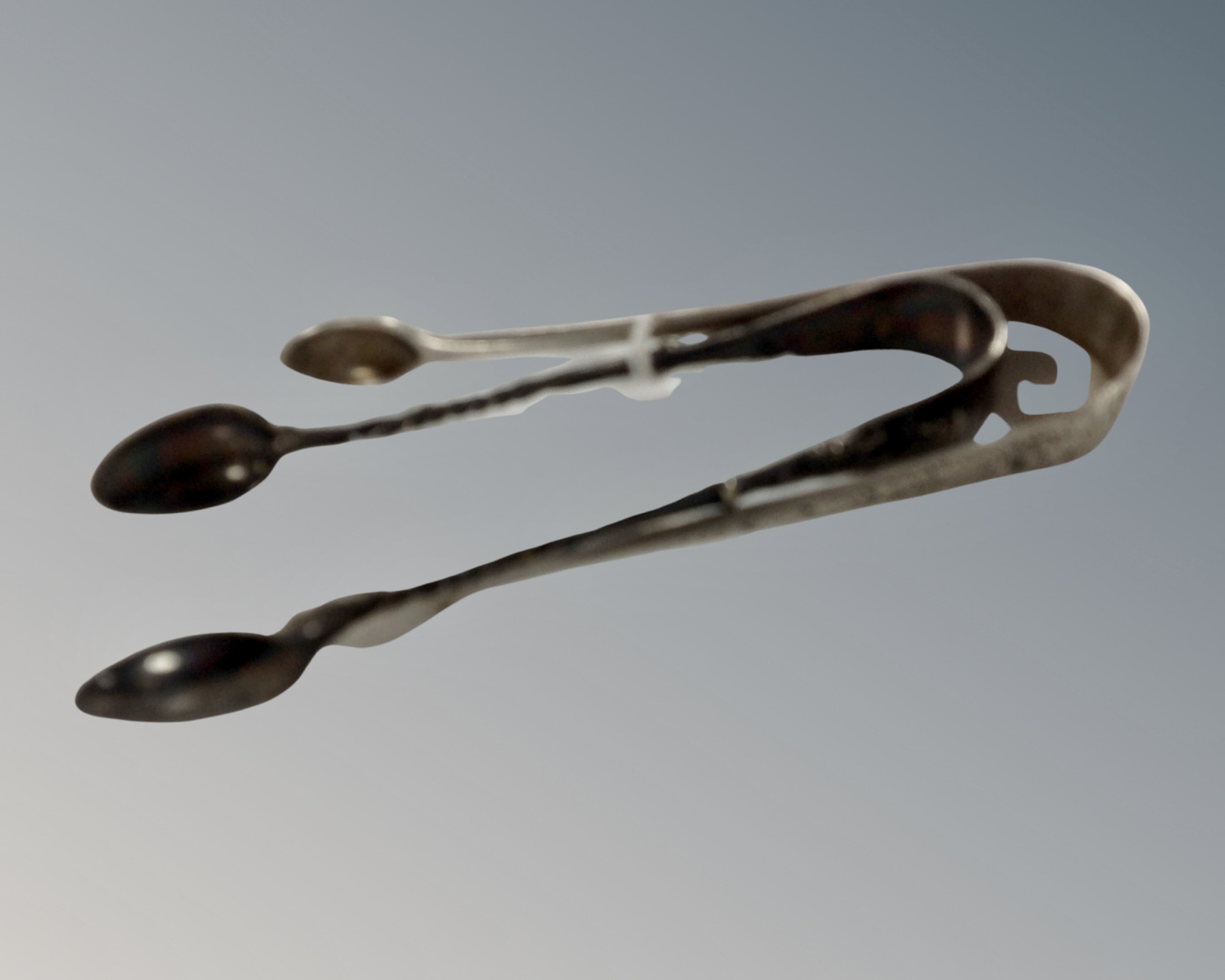 A set of silver sugar tongs (22g) and a set of plated apostle tongs