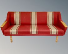 A three piece Danish 20th century lounge suite in red striped fabric with oak arms and legs