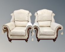 A pair of contemporary armchairs upholstered in cream classical fabric raised on brass castors