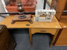 A New Home electric sewing machine in teak effect table
