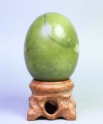 Natural polished Hsiuyen jade crystal egg stone with stand.