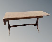 A mahogany Regency style flap ended coffee table on brass capped feet