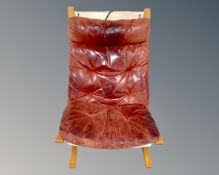 A late 20th century lounger chair with a Burgundy buttoned leather cushion