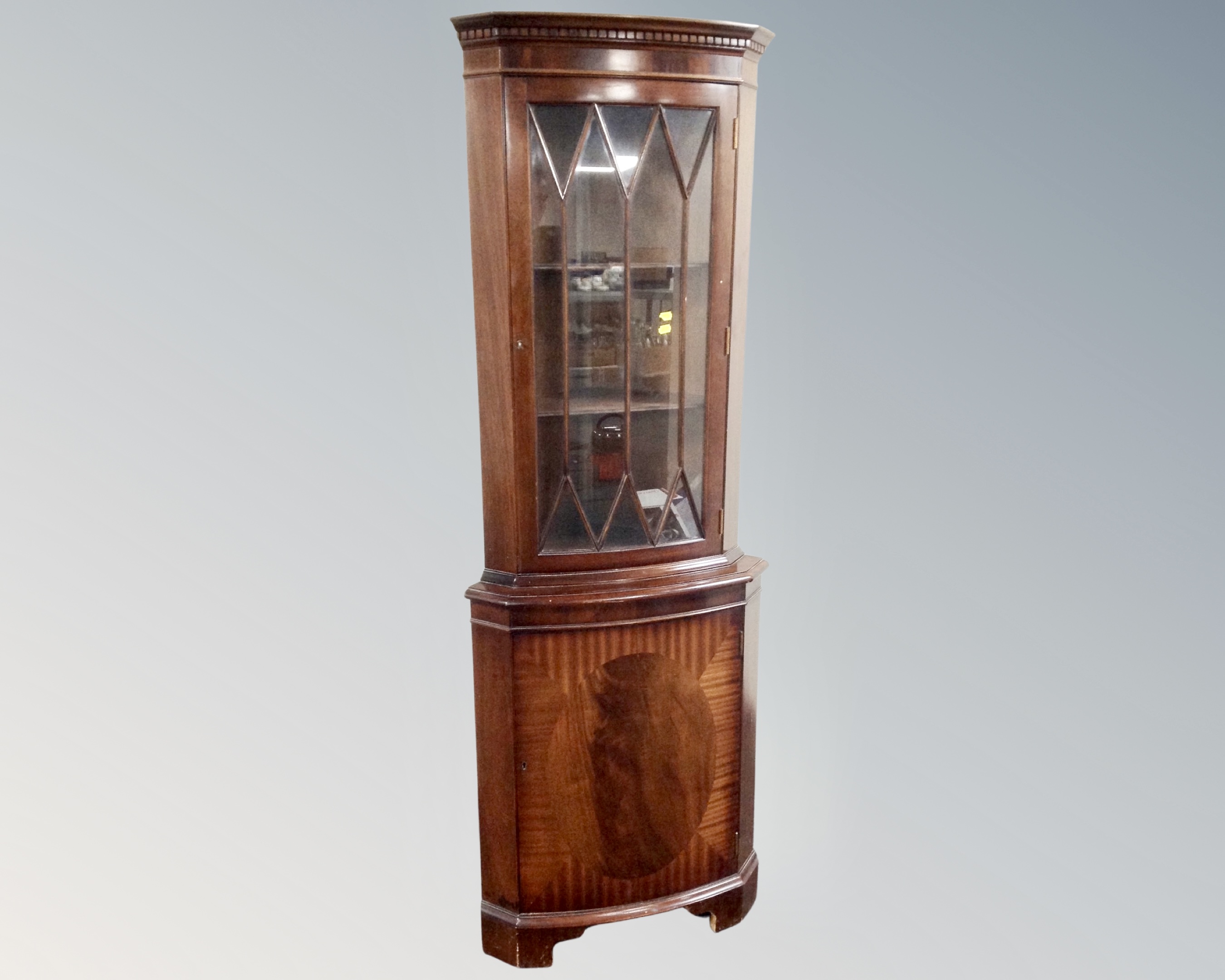 A reproduction mahogany corner display cabinet.