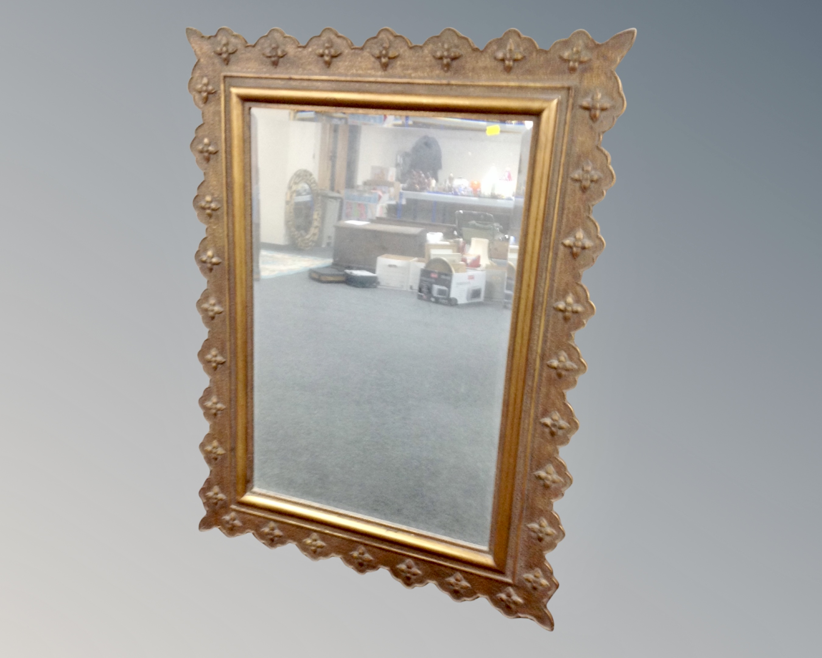 A contemporary bevelled mirror in an antique style frame