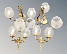 A pair of brass three-way pendant light fittings with etched glass shades,