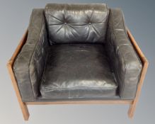 A Danish wooden framed armchair with black leather cushions