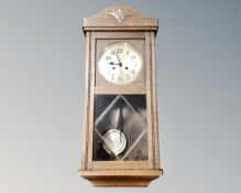 An early 20th century oak eight day wall clock with silvered dial