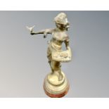 A bronze figure on socle base depicting a lady holding a dove.