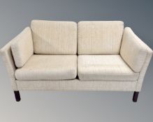 A 20th century Danish two seater settee in beige fabric